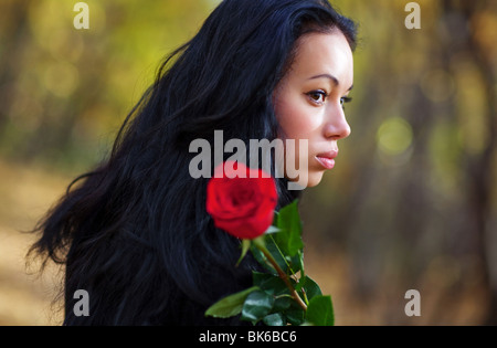 Junge Brünette Frau mit roter rose Porträt. Stockfoto