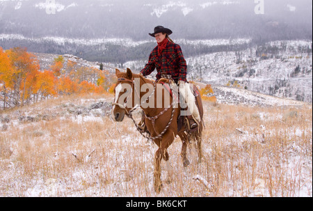 Cowgirl Reiten im Herbst Schnee Stockfoto