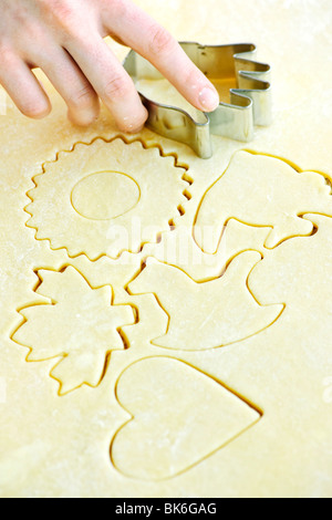 Cookie-Formen in gerollten Teig mit Cutter schneiden Stockfoto