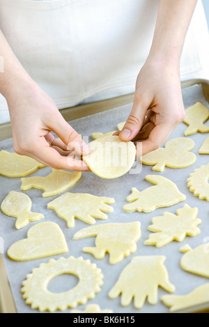 Koch Platzierung Ausschnitt Cookie Teig Formen auf Tablett zum Backen Stockfoto