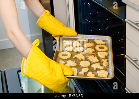 Einnahme von frisch gebacken Shortbread Cookies aus dem Ofen in der Küche Stockfoto