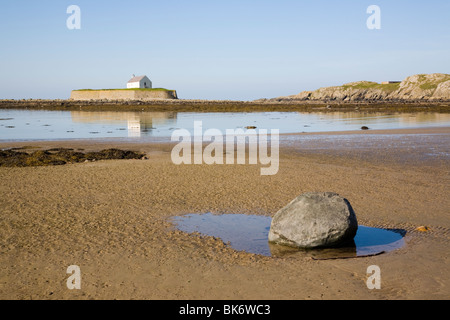 Historische Llangwyfan Kirche aus dem 12. Jahrhundert auf kleinen Gezeiten Insel über Wasser von Porth Cwyfan Bay. Aberffraw ANGLESEY Wales UK Stockfoto