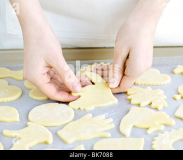 Koch Platzierung Ausschnitt Cookie Teig Formen auf Tablett zum Backen Stockfoto