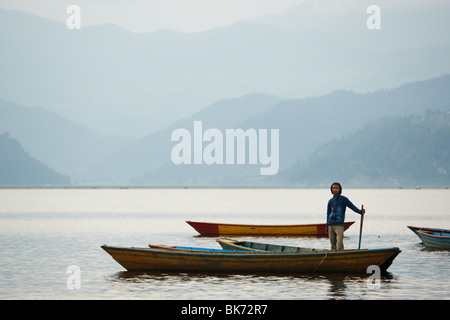 Ein Mann steht in einem Kanu auf Pewha-See in Pokhara, Nepal auf Montag, 26. Oktober 2009. Stockfoto