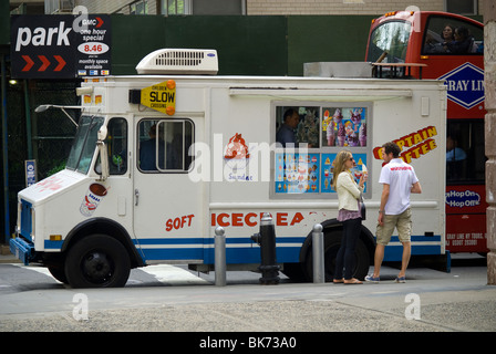 Eis-Liebhaber genießen ein Frostiges Vergnügen von einem Kapitän Softee Softeis LKW in Greenwich Village in New York Stockfoto