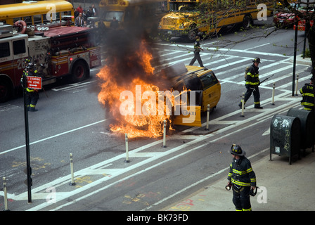 Mitglieder der FDNY löschen ein Taxi, das an der Ninth Avenue im New Yorker Stadtteil Chelsea Feuer gefangen hat Stockfoto