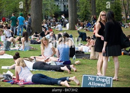 New Yorker und Besucher nutzen das warme Frühlingswetter auf einer Grünfläche im Washington Square Park in New York Stockfoto