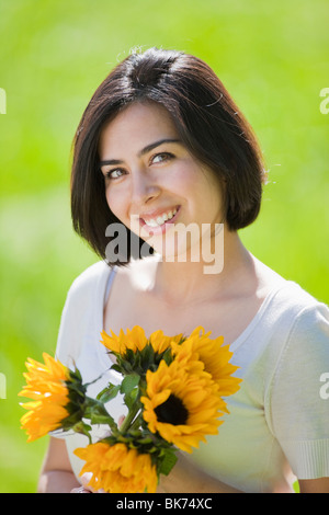 schöne, junge Hispanic Frau in eine Wiese mit Blumen Stockfoto