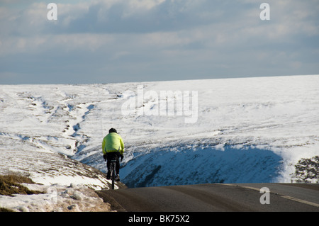 Radfahrer auf der A57 Snake Pass Straße im Winter, in der Nähe von Glossop, Peak District, Derbyshire, England, UK Stockfoto