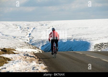 Radfahrer auf der A57 Snake Pass Straße im Winter, in der Nähe von Glossop, Peak District, Derbyshire, England, UK Stockfoto