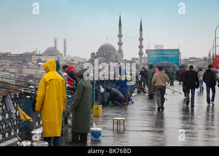 Fischer und Fußgänger auf der Galata-Brücke, die das Goldene Horn in Istanbul, Türkei erstreckt. Stockfoto