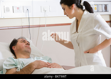 Krankenschwester nehmen Temperatur des Patienten Stockfoto
