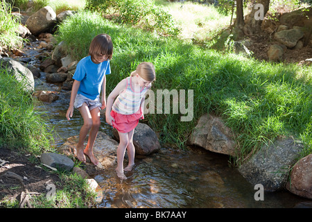 Jungen und Mädchen im Fluss zu Fuß Stockfoto