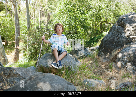 Junge sitzt auf Felsen Stockfoto