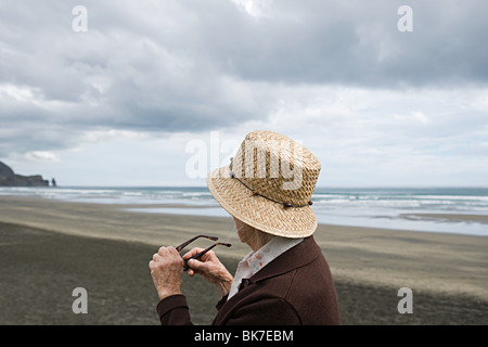 Ältere Frau am Piha Beach, Auckland Stockfoto