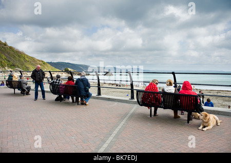 Ältere Touristen sitzen am Strand von Looe in Cornwall.  Foto von Gordon Scammell Stockfoto