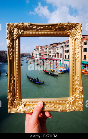 Venedig - Blick auf den Canal Grande und Gondeln in Venedig durch golden verzierten Bilderrahmen, Italien Stockfoto