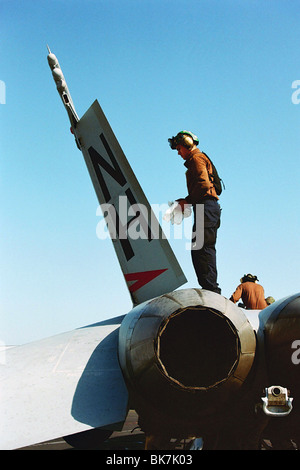 Ein naval Pilot reinigt und Dienstleistungen eine F-18A Hornet an Bord der Flugzeugträger USS Nimitz in den Persischen Golf, während des Irak-Kriegs 2003. Stockfoto