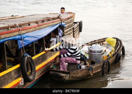 Verkauf von Speisen und Getränke von einem kleinen Boot Passagiere auf eine Riverferry Tho River im Mekong-Delta Vietnam kann Frau Stockfoto