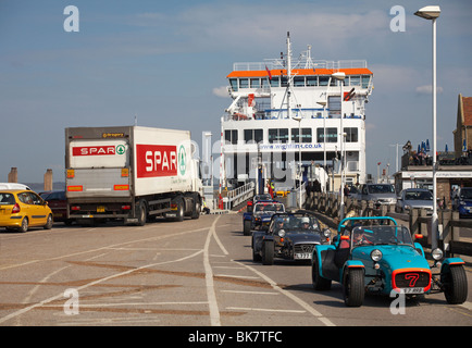 Fahrzeuge, die von der Wightlink Fähre in Yarmouth, Isle of Wight, Hampshire UK fahren, einschließlich Caterham Lotus 7 Autos Stockfoto