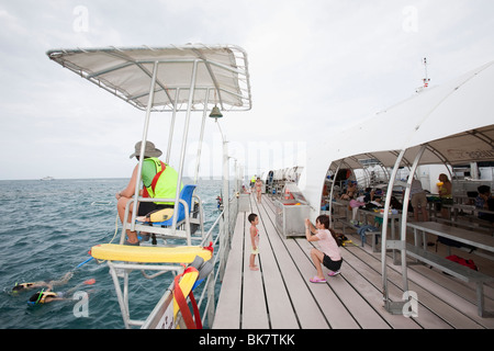 Ein Bademeister wacht über Touristen Schnorcheln vom Tauchen und Schnorcheln Plattform verankert, das Great Barrier Reef vor Cairns Stockfoto