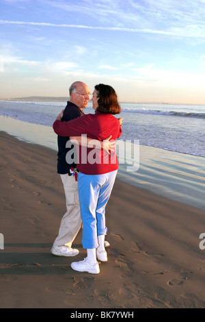 Ältere Paare tanzen am Strand bei Sonnenuntergang Stockfoto