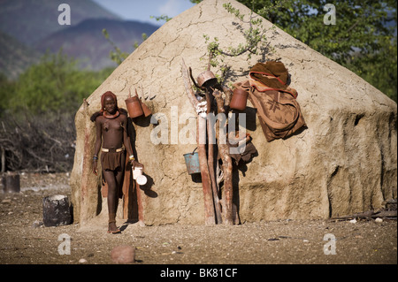 Himba Frau vor ihrer Hütte, Kaokoland, Namibia. Stockfoto