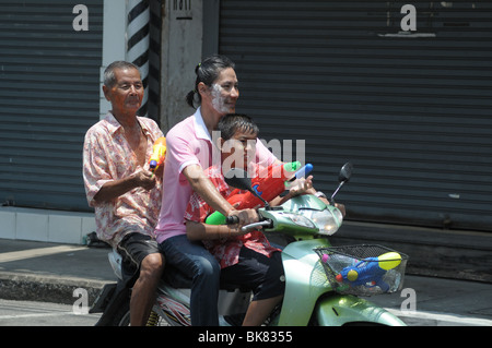 Drei Menschen auf der Rückseite eines Rollers während der Thai Neujahr oder "Songkran" fetsival Stockfoto