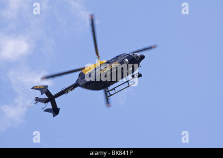 Blaue und gelbe Metropolitan Police Service (MPS) Eurocopter EC145 Helikopter fliegen in einen blauen Himmel Stockfoto