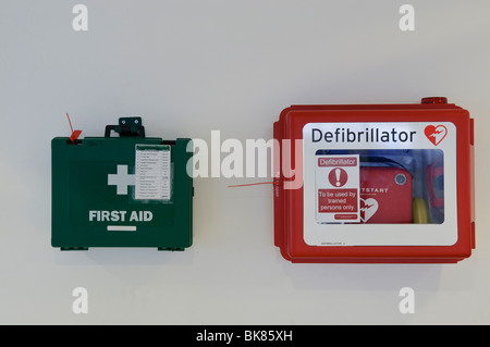 Erste Hilfe Kit und Defibrillator an einer Wand, gebrauchsfertig Stockfoto