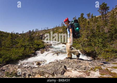 Junge Frau, Wandern, Wandern, Wanderer mit Rucksack, historische Chilkoot Pass Chilkoot Trail, Moose Creek Canyon Wasserfall behi Stockfoto