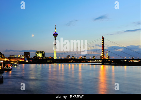 Blick von der Bank des Rheins über den Rhein auf die Skyline von Düsseldorf und dem Rheinturm Tower und Rheinkniebruec Stockfoto