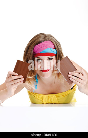 Junge Frau mit zwei Hälften einer Tafel Schokolade Stockfoto