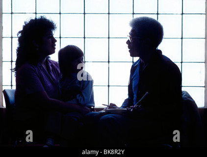 Männliche afrikanische amerikanische Sozialarbeiterin berät einzelne Hispanic Mutter & child; Chicago Illinois Abteilung der öffentlichen Entwicklungshilfe Stockfoto