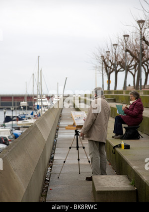 Mann und Frau Malerei Aquarelle in Barcelona Marina Stockfoto