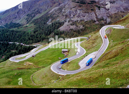 Autos und Tour-Busse fahren um Switchback Kurven auf einer bergigen Straße im Regen, Tirol, Österreich Stockfoto