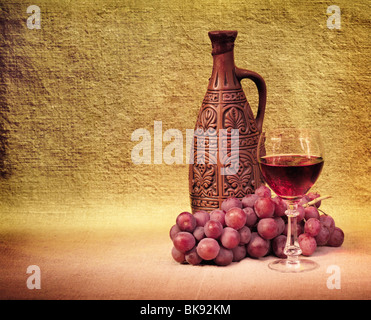 Künstlerische Anordnung der Flaschen Wein, Glas und Trauben Stockfoto