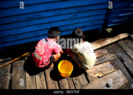 Zwei kambodschanischen jungen Fischen zwischen Holzhäusern in einem Fischerdorf in Koh Kong, Kambodscha. Stockfoto