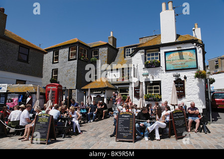 Menschen sitzen vor der Sloop Inn, St. Ives, Cornwall, England, Vereinigtes Königreich Stockfoto