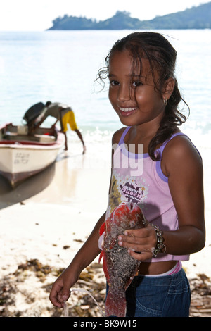 Young Creole Mädchen, etwa 9 Jahre alt, Papageienfische, Baie Lazare, Insel Mahe, Seychellen, Indischer Ozean, A gefangen hält frisch Stockfoto