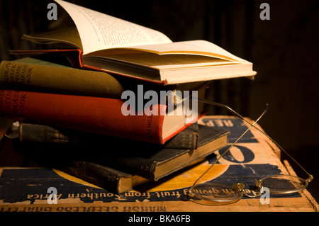 Stapel alter Bücher auf einer Holzkiste mit Lesebrille Stockfoto