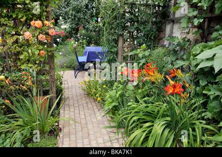 Rosen (Rosa) und Taglilien (Hemerocallis) in einem Garten im Hinterhof. Design: Jutta wahren Stockfoto