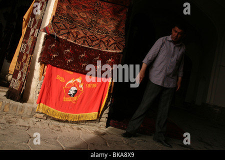 Teppichgeschäft in Buchara, Usbekistan. Sowjet-Ära Flagge der junge Pionier Organisation werden mit Bucharan Teppiche verkauft. Stockfoto