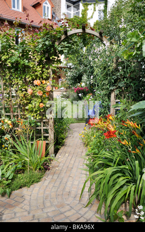 Rosen (Rosa) und Taglilien (Hemerocallis) in einem Garten im Hinterhof. Design: Jutta wahren Stockfoto