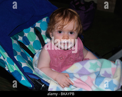 Babymädchen mit Dummy In Push Chair Peterborough England Stockfoto