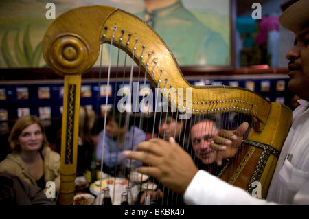 Touristen sehen einen Harfe-Spieler im Tenampa Restaurant, einem berühmten Mariachi-Gelenk in Mexiko-Stadt durchführen Stockfoto