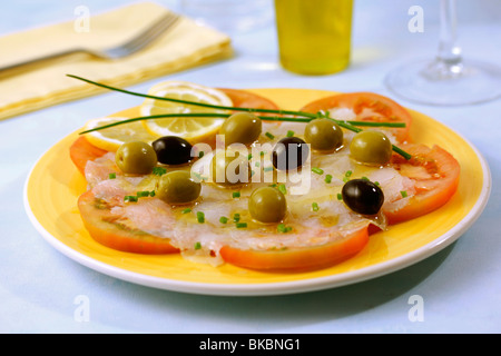 Kabeljau-Carpaccio auf Tomaten. Rezept zur Verfügung. Stockfoto