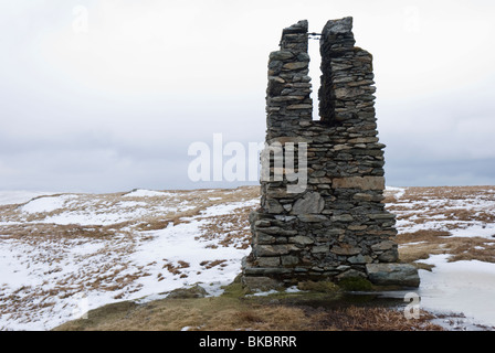 Überreste einer Vermessungssäule, die im Bau des Haweswater-Staudamms auf dem schneebedeckten Tarn Crag im Cumbrian Lake District verwendet wurde. Stockfoto