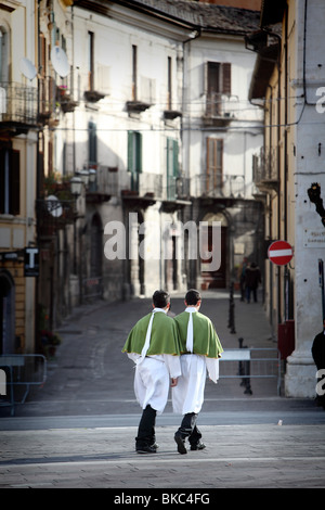 In einer nahezu zeitlose Szene überqueren zwei Jugendliche in zeremoniellen Ostersonntag Kostüm der Piazza Garibaldi in Sulmona, Abruzzen, Italien Stockfoto