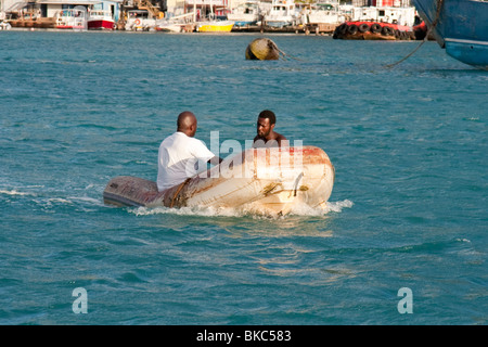 Zwei arbeitende Männer in einem Schlauchboot arbeiten in Philipsburg, Sint Maarten Stockfoto